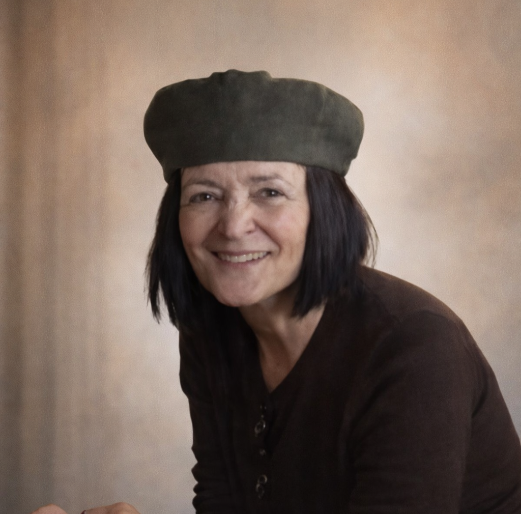 Mary Douglas smiling, wearing an olive cap